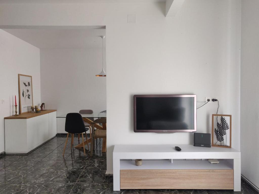 uma sala de estar com televisão numa parede branca em Piso de 110 m2 en el centro de Figueres em Figueres