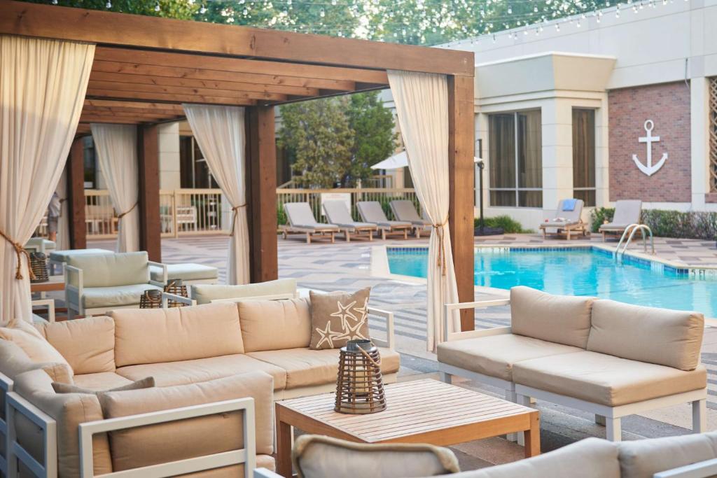 un patio con sofás y una piscina en DoubleTree by Hilton Dallas Market Center en Dallas