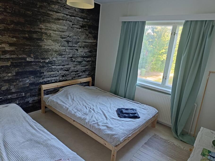 a small bedroom with a bed and a window at Rauhallinen kaksio, puusauna käytettävissä in Varkaus