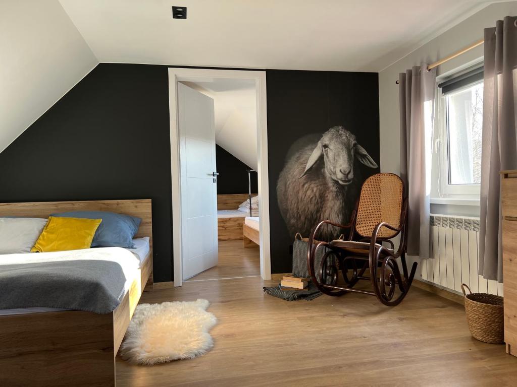 a bedroom with a mural of a sheep and a chair at Dablin 9 in Korbielów
