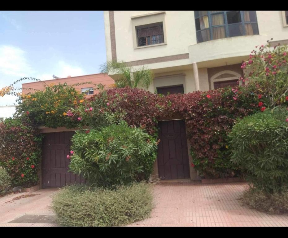 傑迪代的住宿－Apartment El Jadida，一座带两个车库门和鲜花的建筑