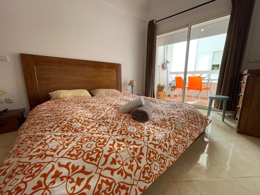 a bedroom with a large bed with a large window at Moderne appartement in Larache