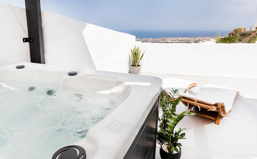 a white bath tub sitting on top of a balcony at Rafael' s Mediteranian Cave Suites in Firostefani