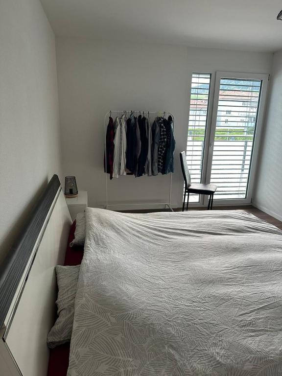 a bedroom with a bed and a chair and a closet at Luxu’rooms in Lignières