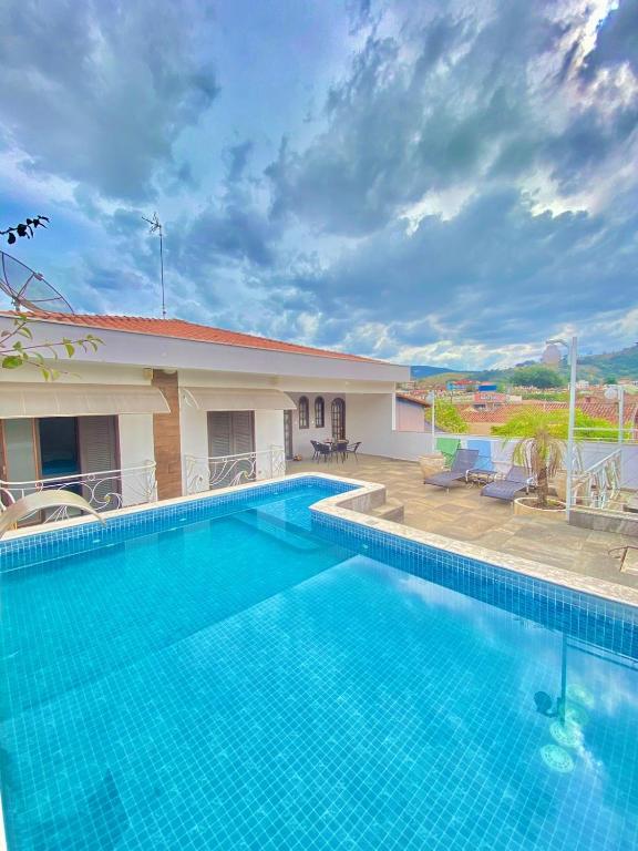 a large swimming pool in front of a house at Refúgio solar in Socorro