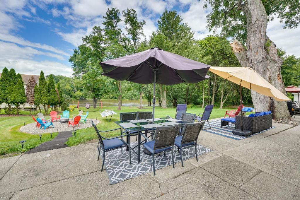 une terrasse avec une table, des chaises et un parasol dans l'établissement Waterfront Wallkill Duplex Home with Fire Pits!, à Wallkill