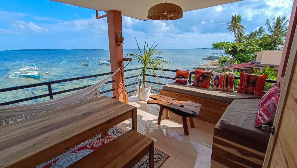 a balcony with benches and a view of the ocean at Casa Talisay in General Luna