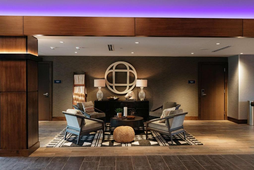 een lobby met 2 stoelen en een tafel in een gebouw bij Revel Hotel, Tapestry Collection By Hilton in Urbandale