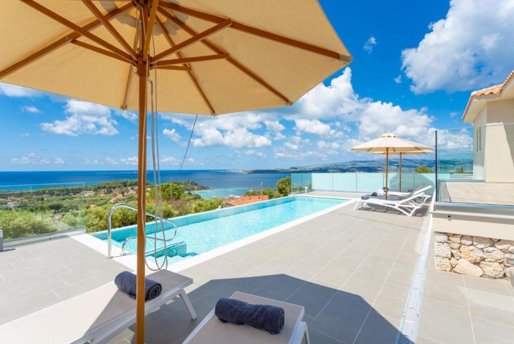 een villa met een zwembad en een parasol bij Villa Lassi Illios in Kefallonia