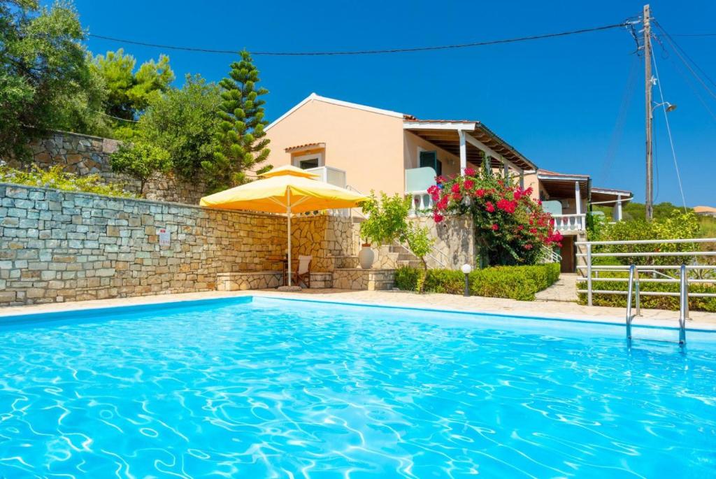 a house with a swimming pool and an umbrella at Dolphin Villa 2 in Porto Ozias