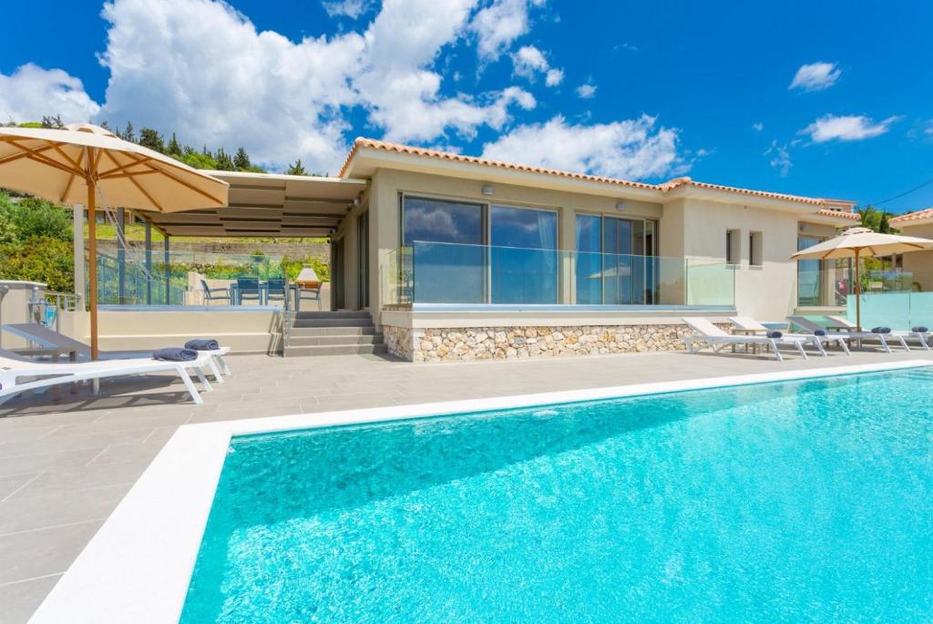 a villa with a swimming pool and a house at Villa Lassi Fos in Kefallonia