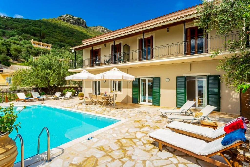 a villa with a swimming pool and a house at Villa Katerina in Katávolos