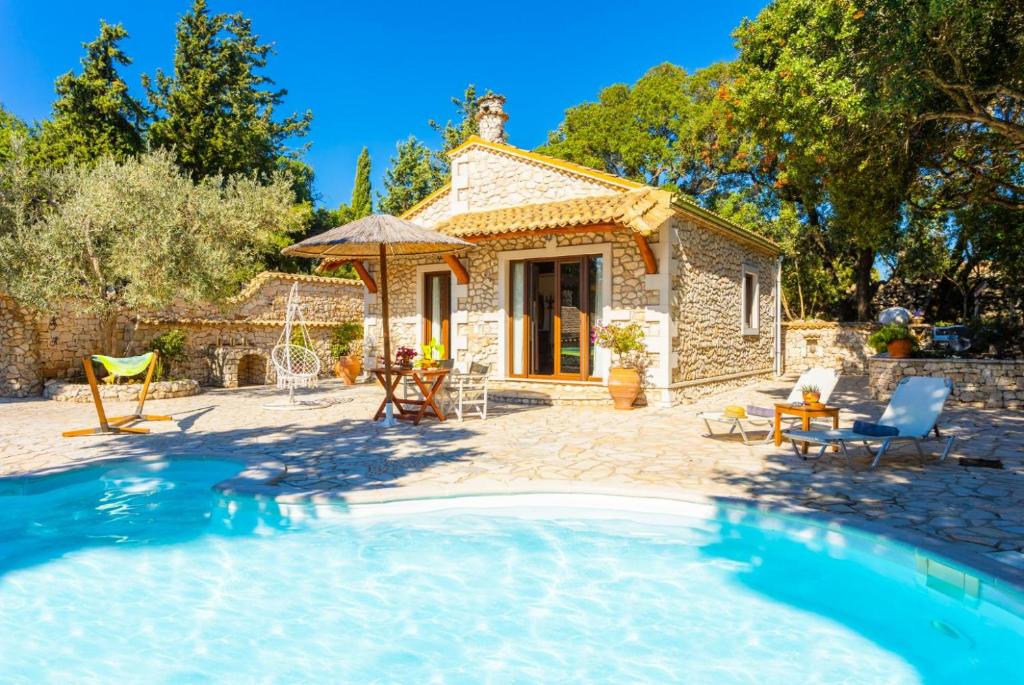 uma pequena casa de pedra com uma piscina em frente em Villa Nionios em Vlachopoulátika