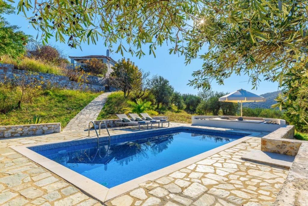 una piscina en un patio con sombrilla en Villa Levanda, en Panormos Skopelos