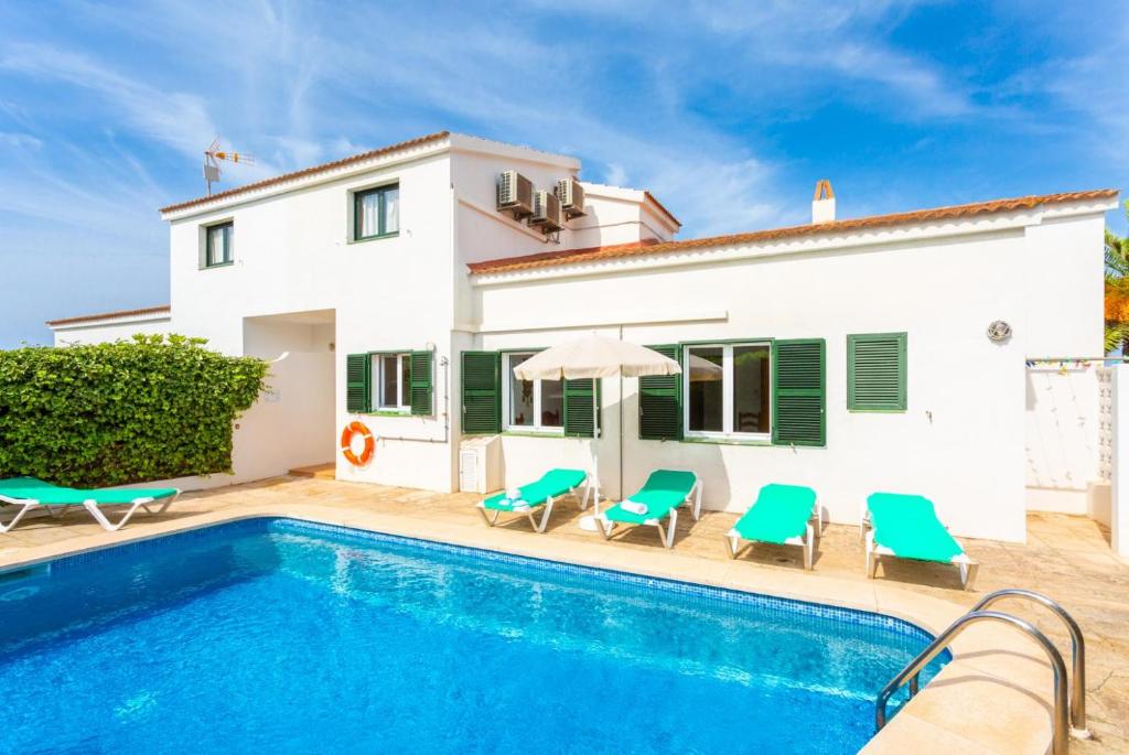 a villa with a swimming pool and a house at Villa Bini Estrella in Es Canutells