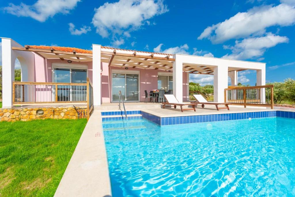 a villa with a swimming pool and a house at Vatsa Beach Villa in Kounopetra