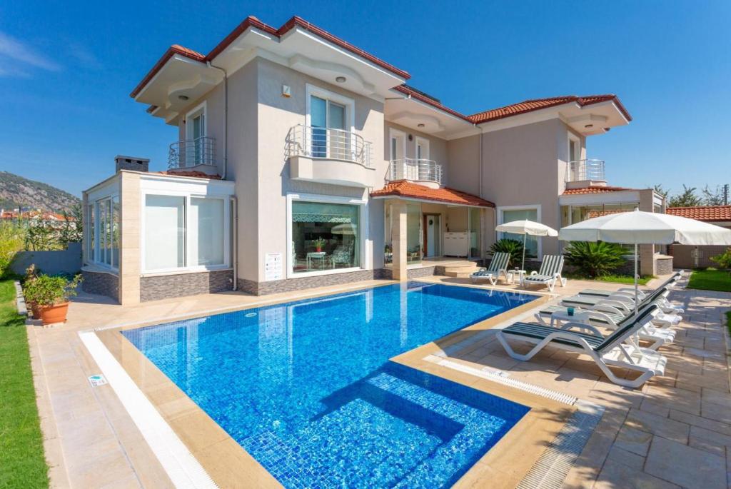 a villa with a swimming pool in front of a house at Villa Nirvana in Mugla