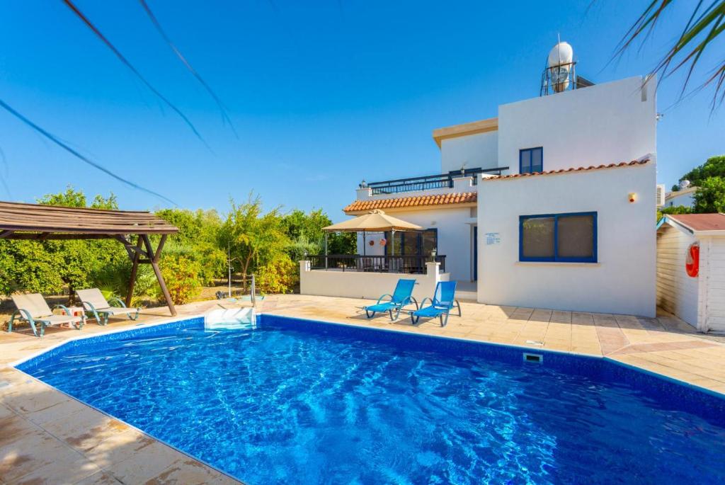 a villa with a swimming pool in front of a house at Villa Charoula Pente in Paphos