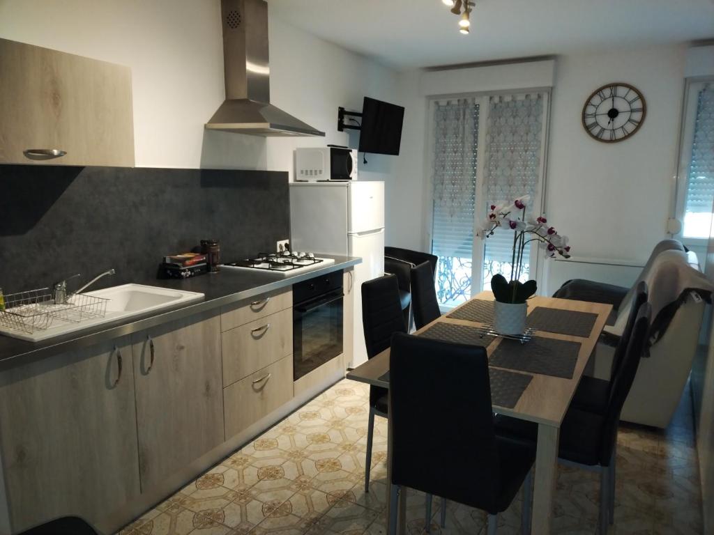 Una cocina y un comedor con una mesa y un fregadero. en Maison, en Damblain