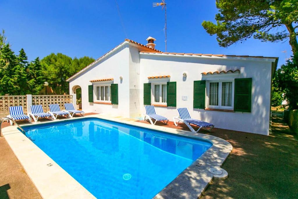 a villa with a swimming pool in front of a house at Villa Trepuco Uno in Punta Prima