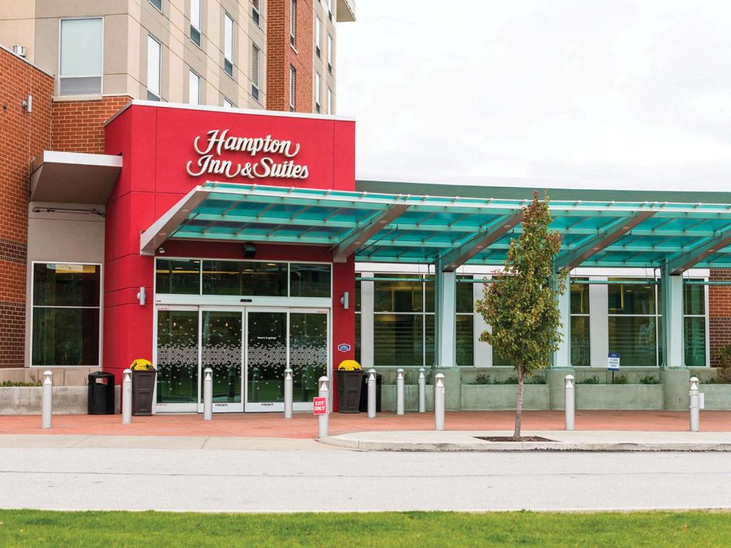 a building with a red sign on the front of it at Hampton Inn & Suites Erie Bayfront in Erie