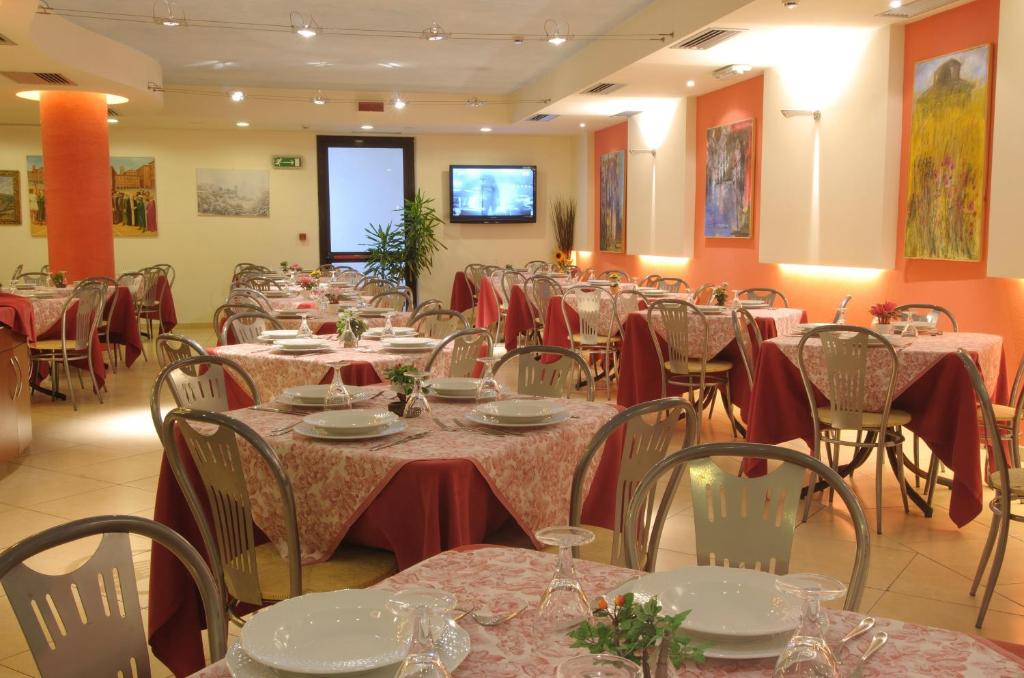 jadalnia wypełniona stołami i krzesłami w obiekcie Palace Hotel Due Ponti w Sienie