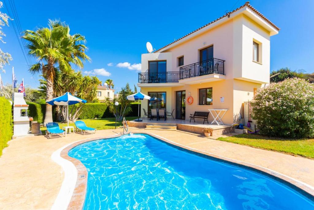 a villa with a swimming pool in front of a house at Villa Halima Georgios in Polis Chrysochous
