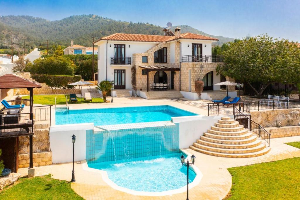 a villa with a swimming pool and a house at Villa Minoas in Argaka