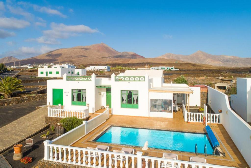 a villa with a swimming pool and mountains in the background at Villa Sol Y Mar in Yaiza