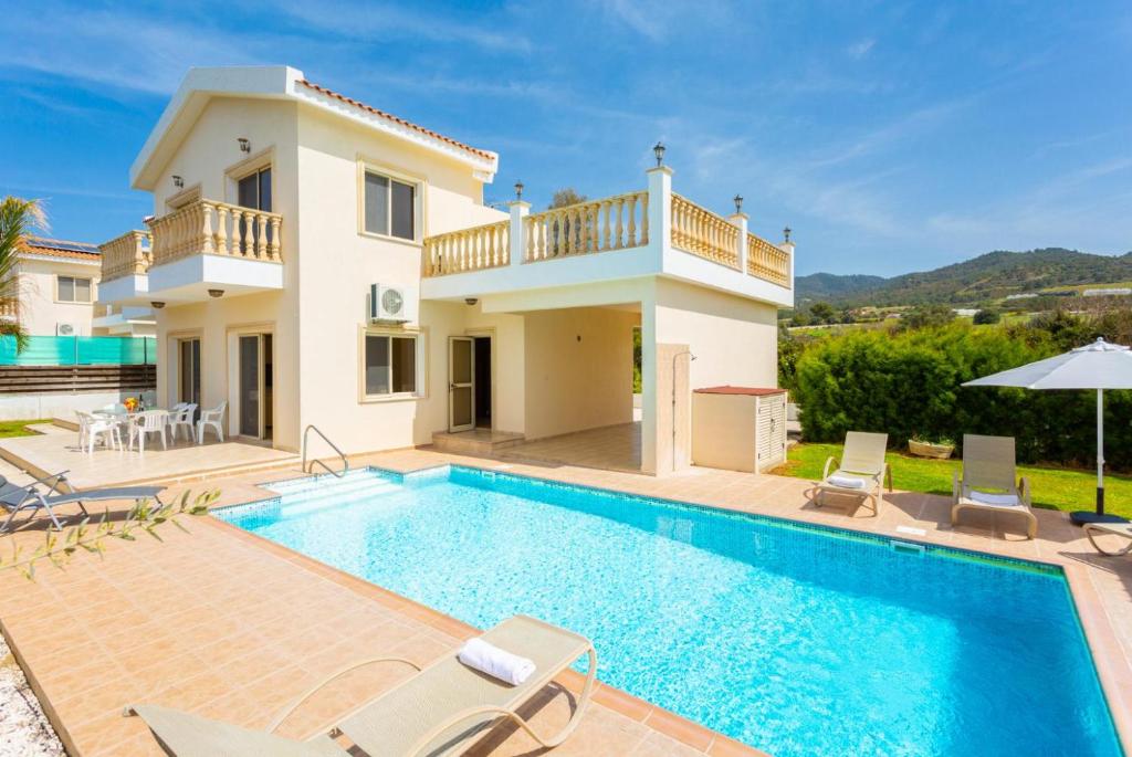 a villa with a swimming pool and a house at Villa Rose in Paphos