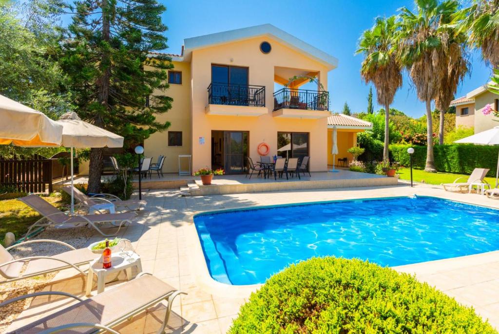 a villa with a swimming pool in front of a house at Villa Halima Stefanos in Polis Chrysochous
