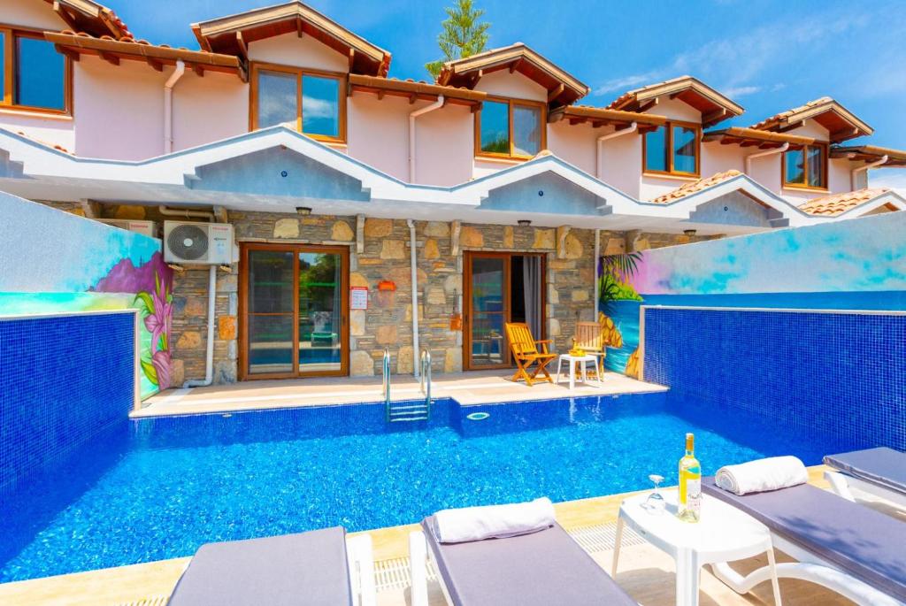 a villa with a swimming pool in front of a house at Villa Asli Paradise in Mugla