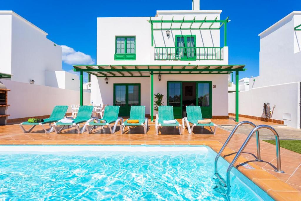a villa with a swimming pool and a house at Villa Costa Papagayo 5 in Playa Blanca