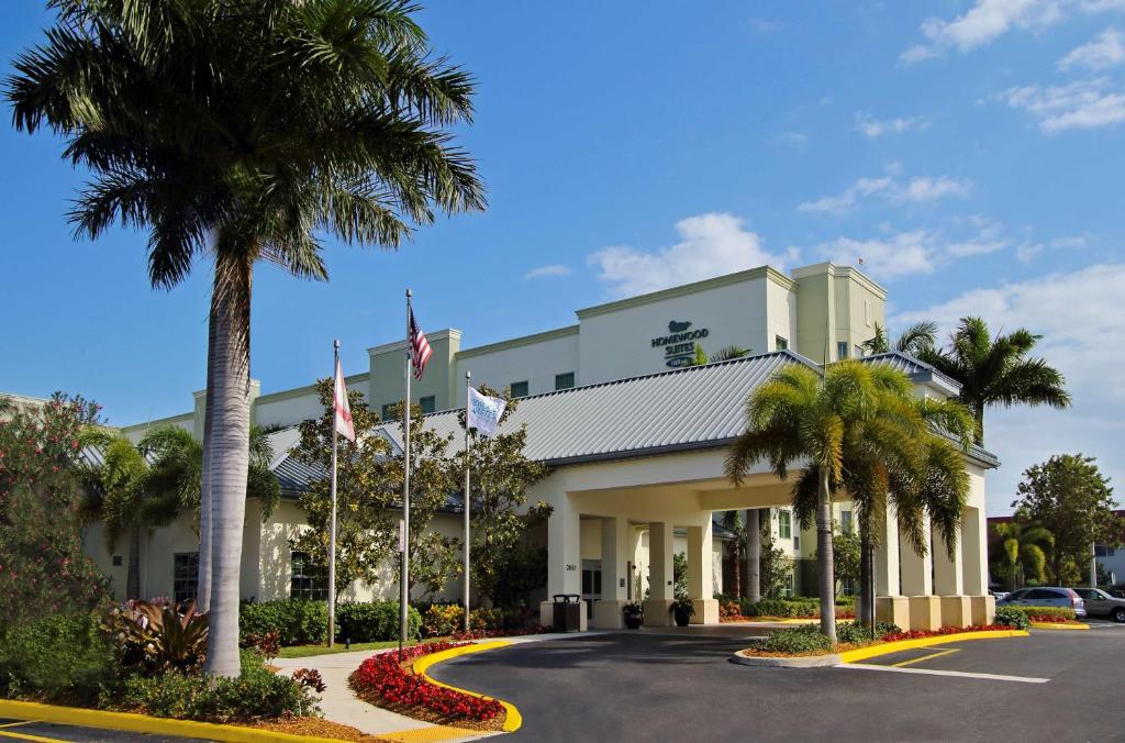 un hôtel avec des palmiers devant un bâtiment dans l'établissement Homewood Suites by Hilton Fort Lauderdale Airport-Cruise Port, à Dania Beach