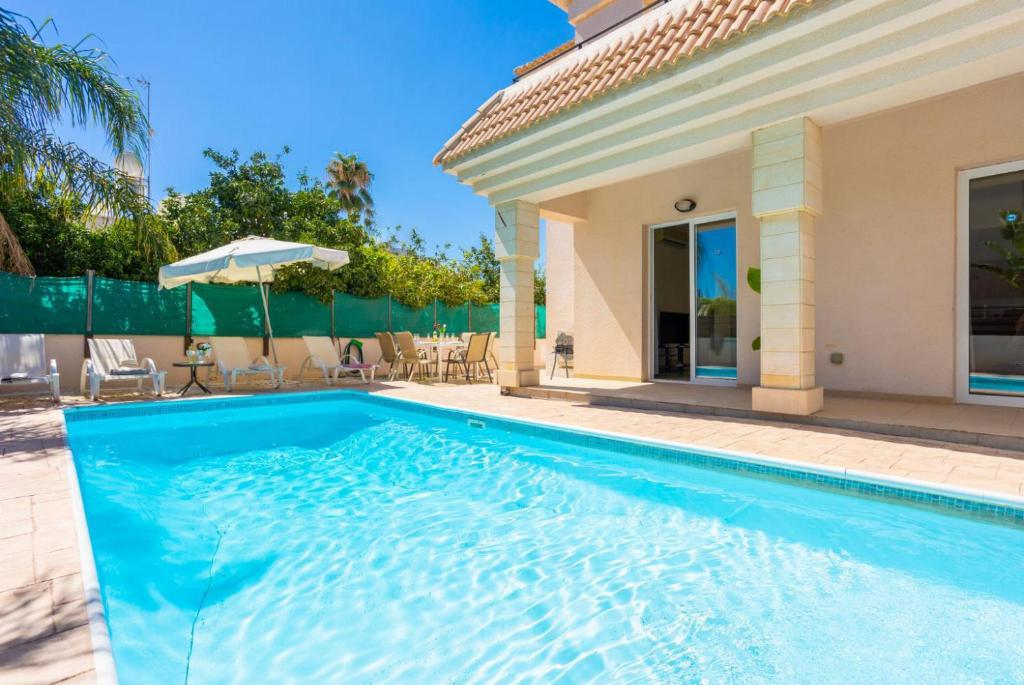 een zwembad voor een huis bij Villa Miracle in Paralimni