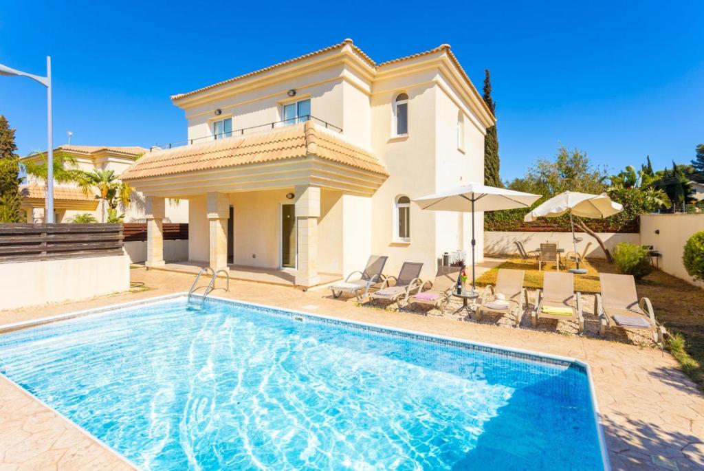 uma villa com piscina em frente a uma casa em Villa Miranda em Paralimni