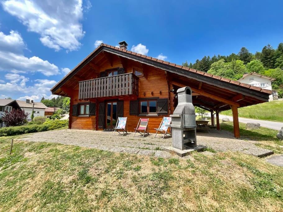 une cabane en rondins avec deux chaises et un monument dans l'établissement Chalet Baudelaire, 4* beau et authentique, à Xonrupt-Longemer