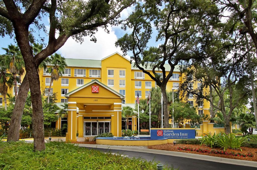 a yellow building in front of a park at Hilton Garden Inn Ft. Lauderdale Airport-Cruise Port in Dania Beach