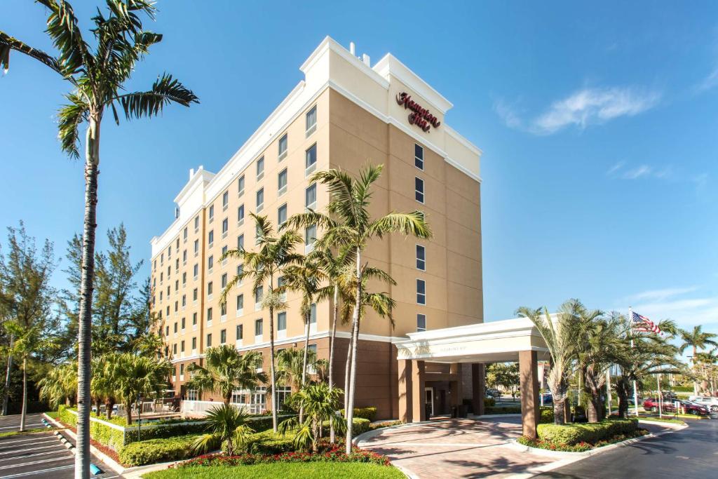a hotel with palm trees in front of a building at Hampton Inn Hallandale Beach-Aventura in Hollywood