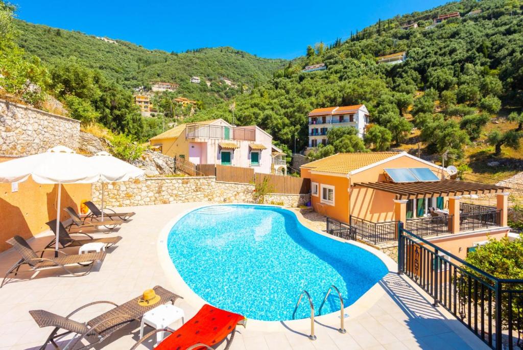 a villa with a swimming pool on a hill at Villa Konstantinos in Katávolos