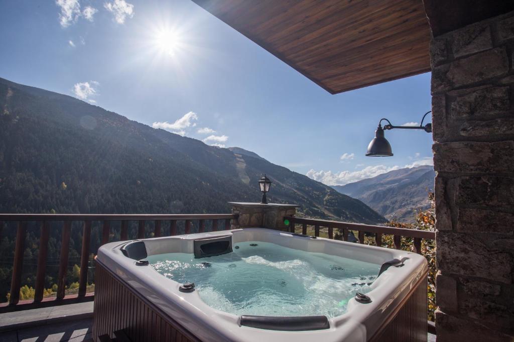 a hot tub on a balcony with a view of mountains at Luxury Treeline Residence with Hot Tub - By Ski Chalet Andorra in Soldeu