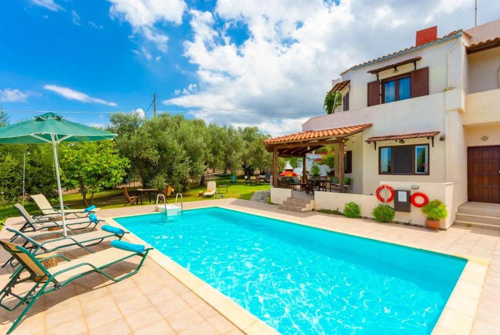 een villa met een zwembad en een huis bij Villa Armi in Episkopí- Rethimno