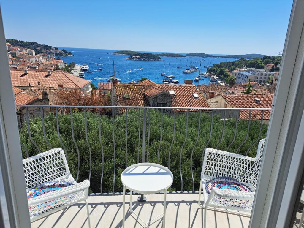 a balcony with two chairs and a view of the water at Ida view in Hvar