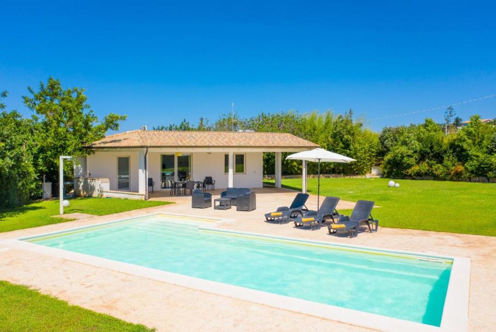 a villa with a swimming pool and a house at Villino Malva in Ragusa