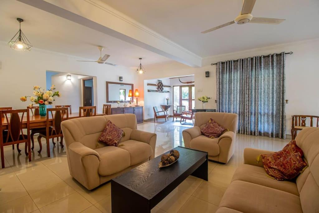 a living room with two couches and a dining room at Spacious 4BR 4BA Family Villa wt Balcony & Lavish Garden in Ratmalana