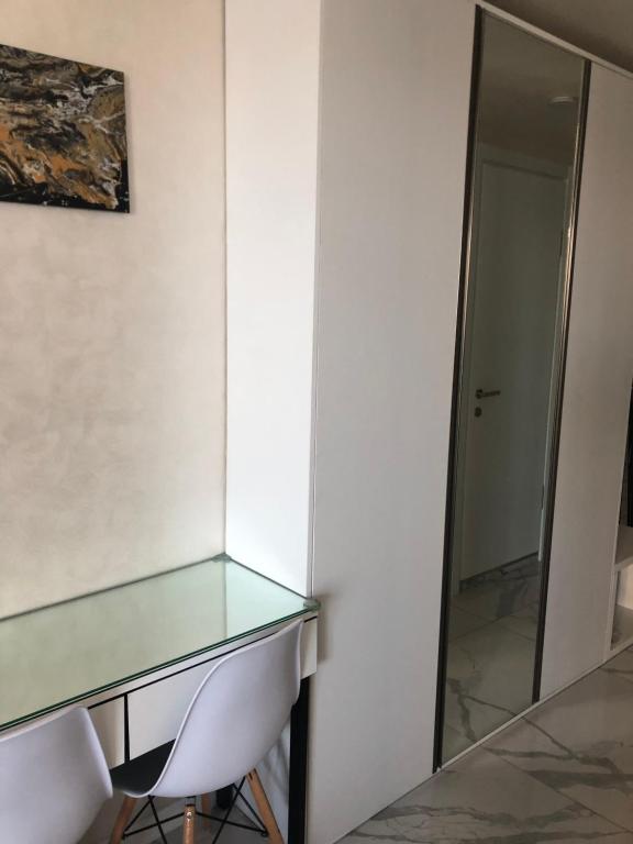 a glass desk and a chair in a room at Black Sea Vi Dari Apartments in Batumi
