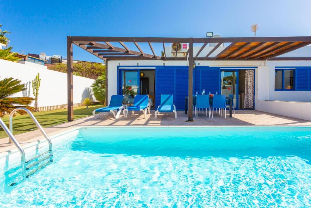 une villa avec une piscine et une maison dans l'établissement Villa Tropical, à Playa Blanca