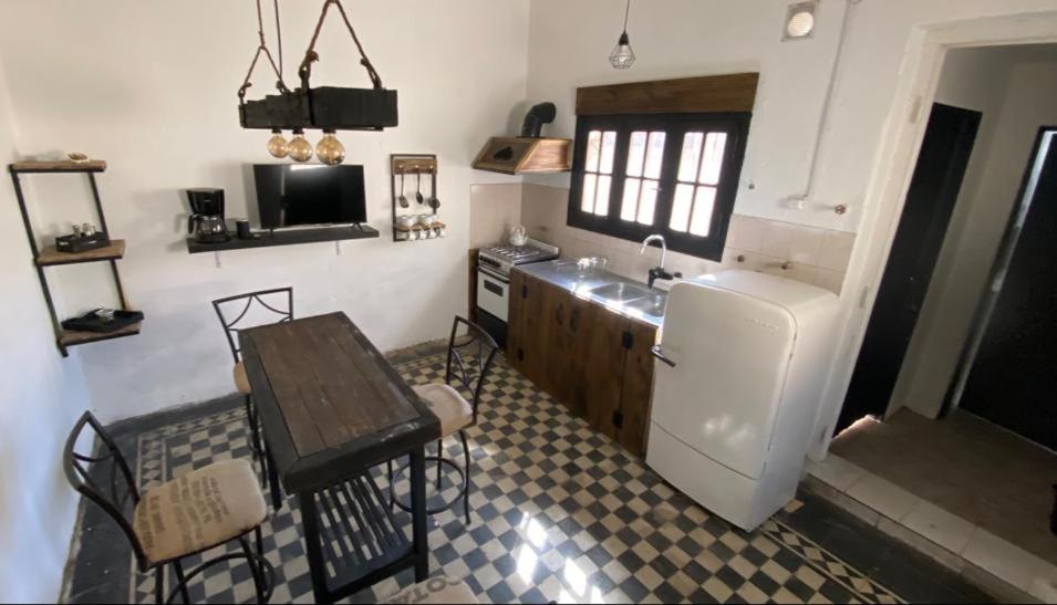 eine Küche mit einer Spüle, einem Tisch und einer Theke in der Unterkunft En Remolinos in Cruz del Eje