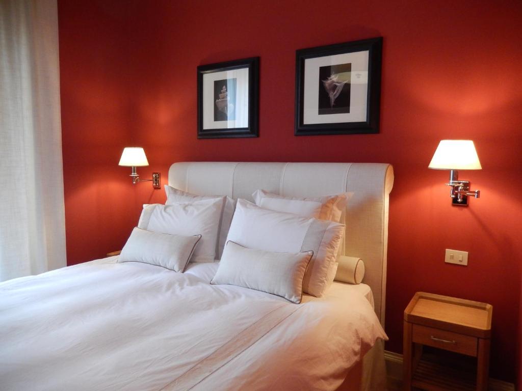 a bedroom with red walls and a white bed with pillows at Villino Fiorentino in Florence