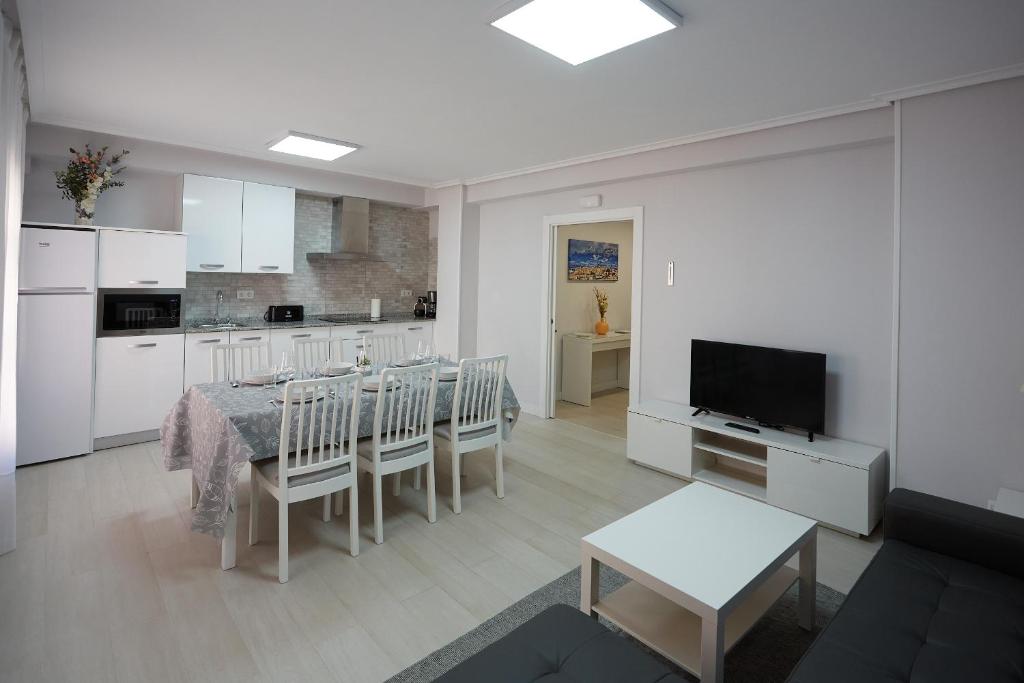 cocina y comedor con mesa y TV en Apartamento Turístico VIANA I, en Viana